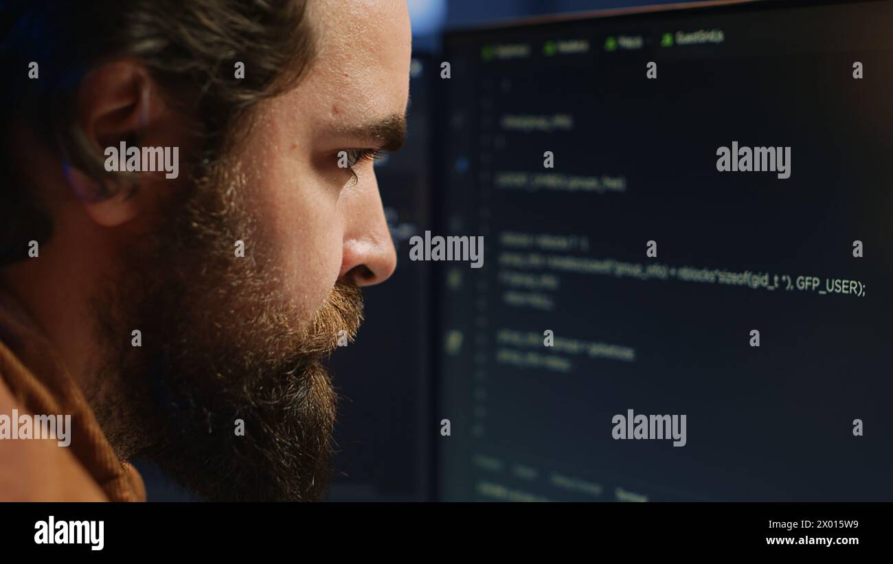 Software engineer concerned, concentrating on finding bugs while coding on computer, extreme close up. Troubled IT professional frowning while looking at screen, confused by script errors, camera A Stock Photo