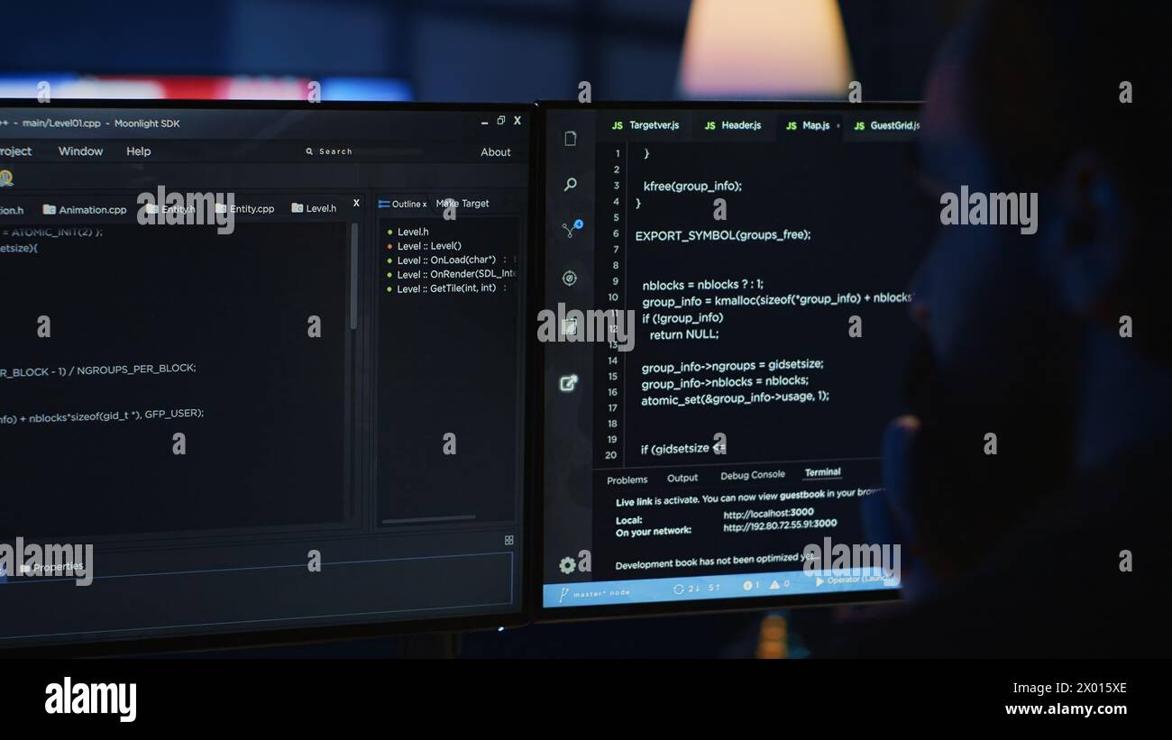 Software engineer writes complex binary code scripts on computer, close up. Teleworking IT specialist in home office using programming to safeguard consumer data, handheld camera shot, camera A Stock Photo