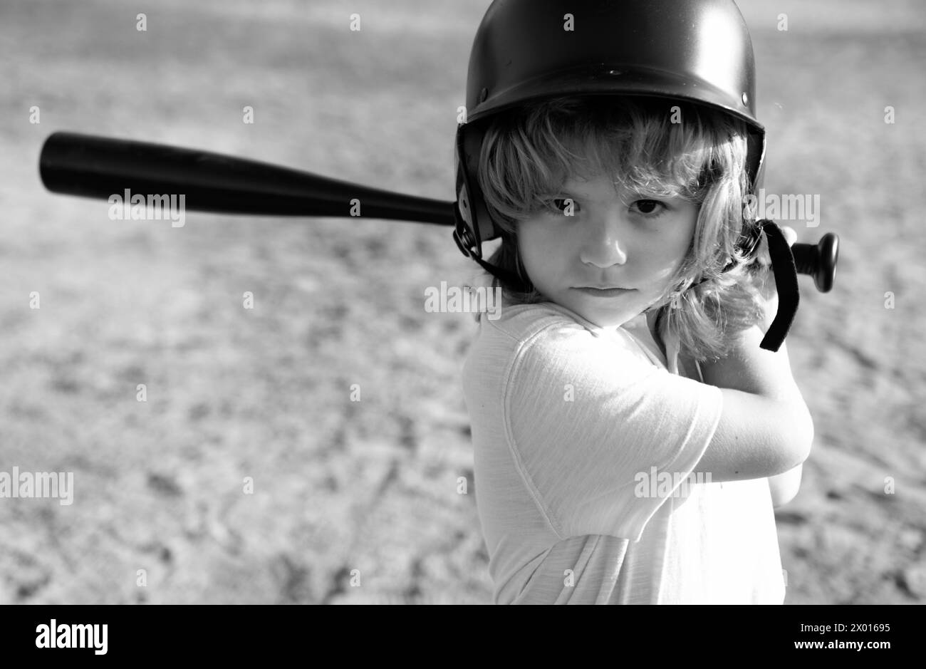 Funny kid up to bat at a baseball game. Close up child portrait Stock