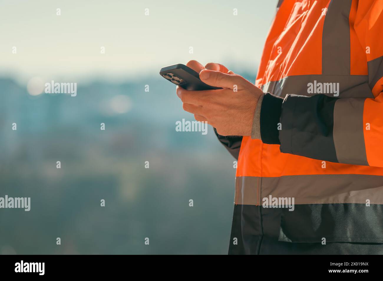 Construction engineer using mobile smart phone on site during inspection, selective focus Stock Photo