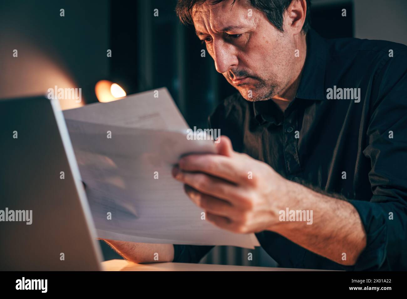 Exhausted businessman reading paper business report in office, selective focus Stock Photo