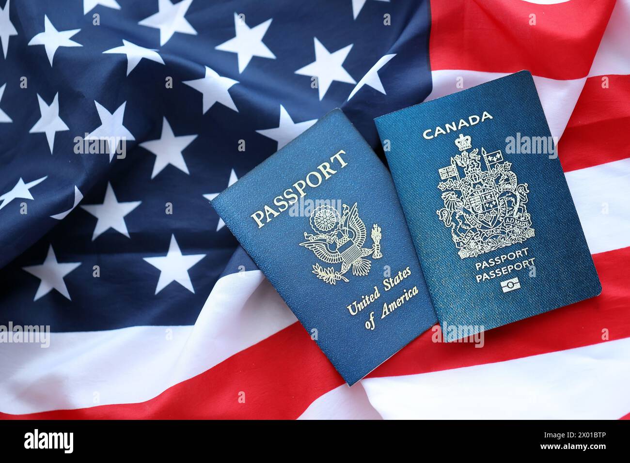 Passport of Canada with US Passport on United States of America folded flag close up Stock Photo