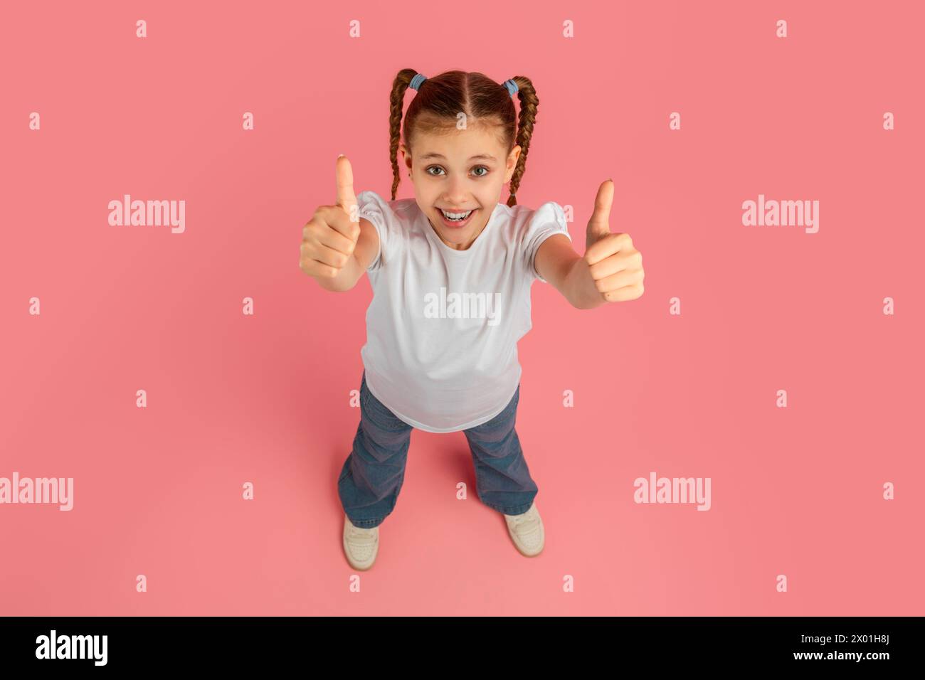 Girl giving thumbs up with confident smile Stock Photo - Alamy