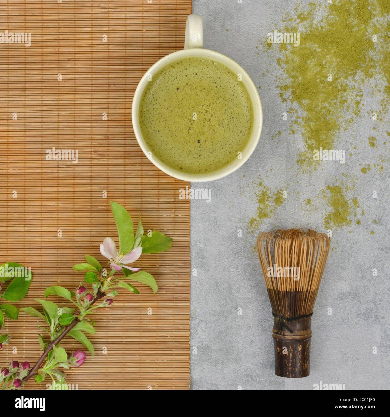 Tea ceremony: matcha, bamboo whisk and twig with leaves, flat lay. Stock Photo