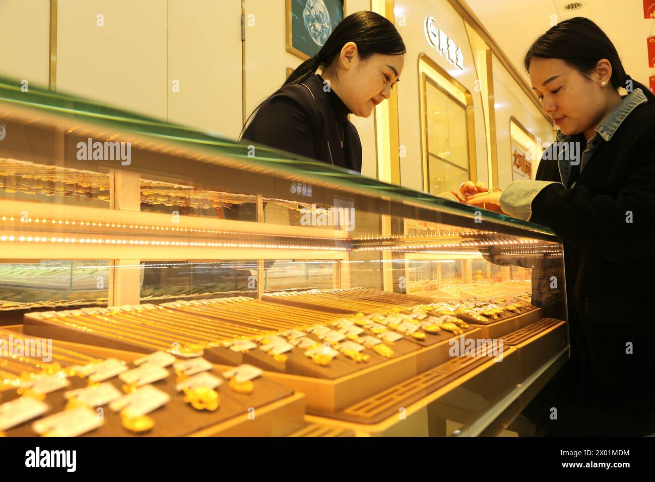 LIANYUNGANG, CHINA - APRIL 9, 2024 - Customers shop for gold jewelry at a gold store in Lianyun district, Lianyungang city, East China's Jiangsu provi Stock Photo