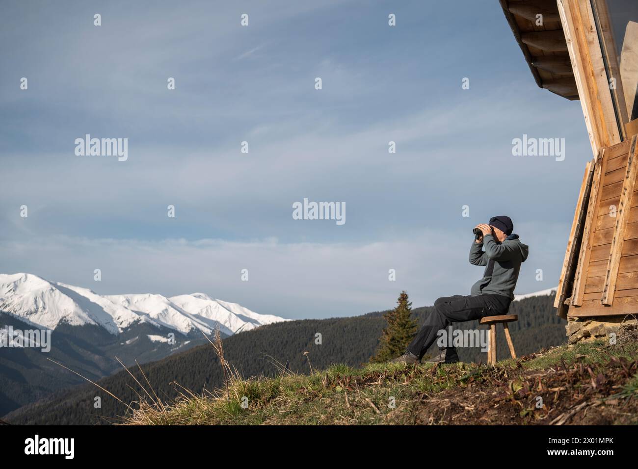 Man birdwatching at Comisu Wildlife Hide, Făgăraș Mountains, Argeș ...