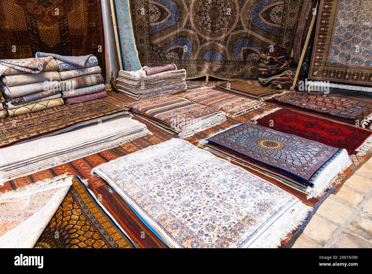 Assortment of oriental silk carpets for sale represented on historic Bukhara bazaar Stock Photo