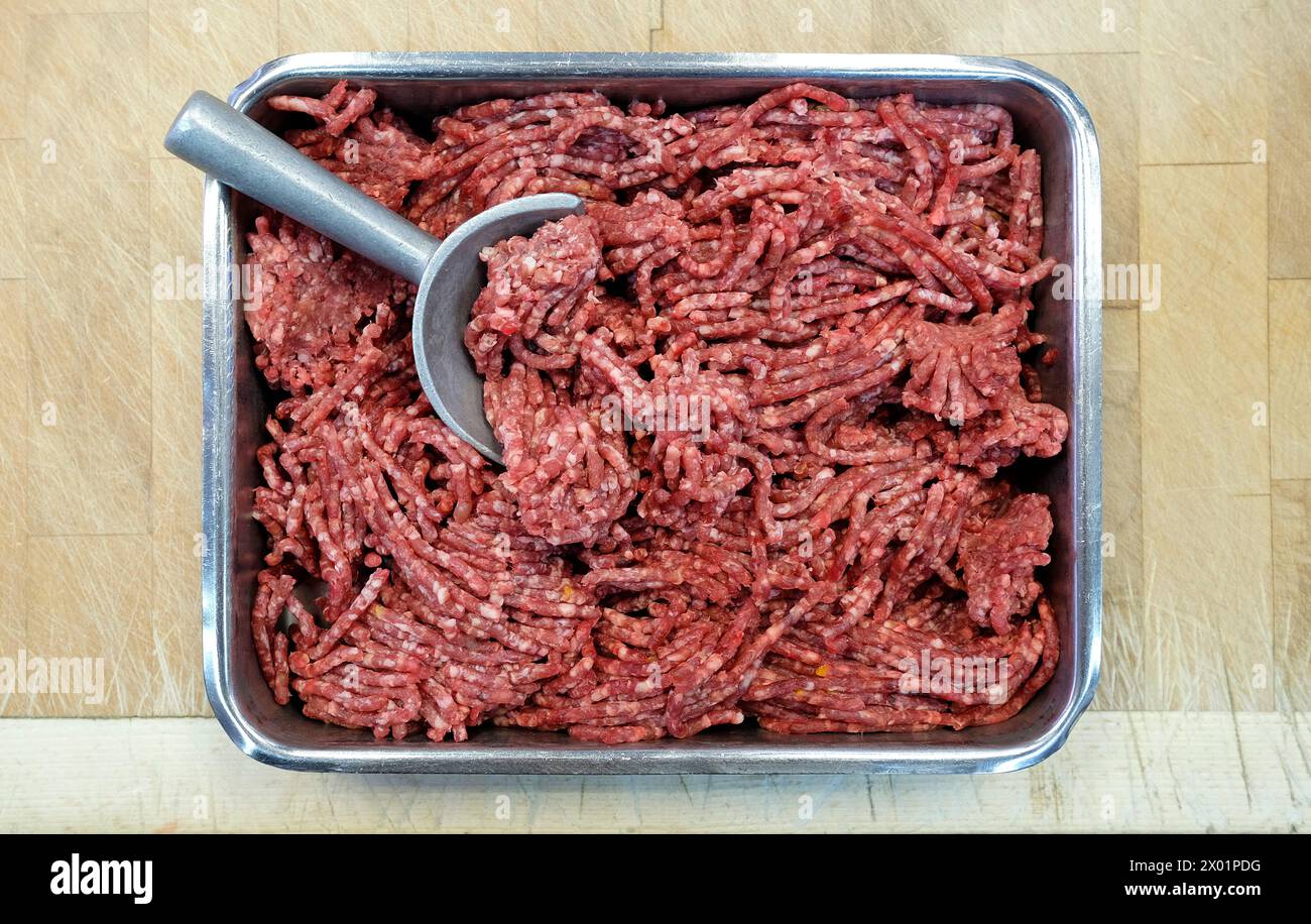 beef mince meat in metal container on butchers table Stock Photo