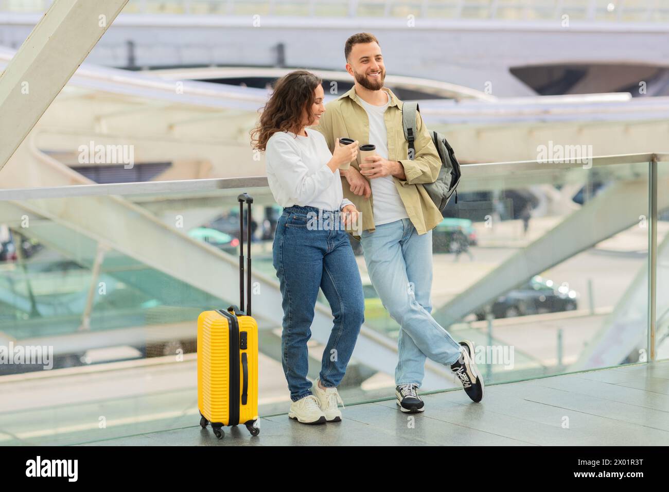 Man and Woman With Takeaway Coffee Waiting Flight At Airport Stock Photo