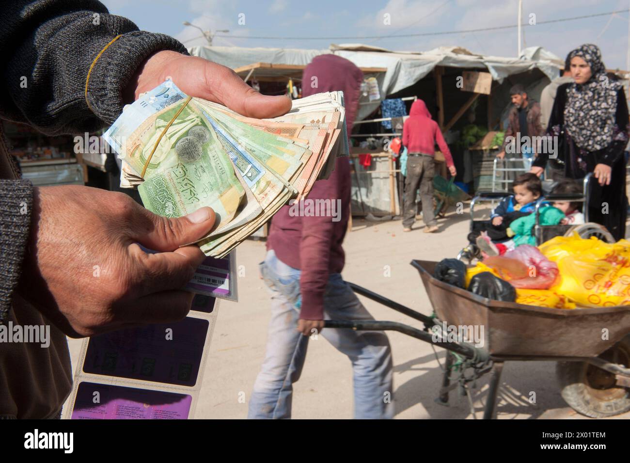 Money Changer at Champs Elisee Mohammed is a Money Changer inside Refugee Camp Al Za atari. He is one of five or six. He helps refugees, migrants and visitors inside the camp to exchange all kinds of currency into local, cash money they can spend at shops and stores arount the camp. Al Za atari, Al Mafraq, Jordan. Mafraq Refugeecamp Al Za atari Al Mafraq Jordan Copyright: xGuidoxKoppesxPhotox Stock Photo