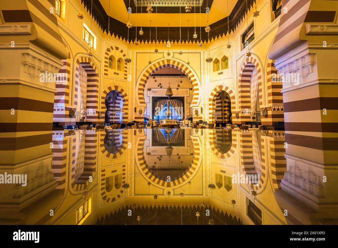 ASWAN, EGYPT - SEPTEMBER 03, 2017: Long exposure of the interior of the 1902 restaurant at the Old Cataract Hotel reflected in a glass table. Stock Photo