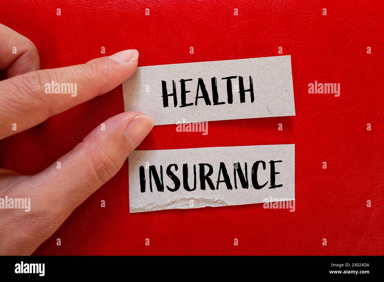 Health insurance words written on ripped paper with red background. Conceptual symbol. Copy space. Stock Photo