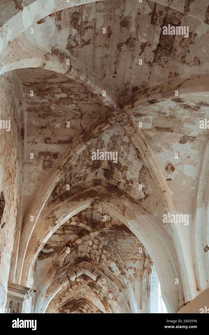 Warm tones envelop the majestic arches and rosette window of the Monasterio de Piedra's cloister, radiating with historical grandeur. Stock Photo