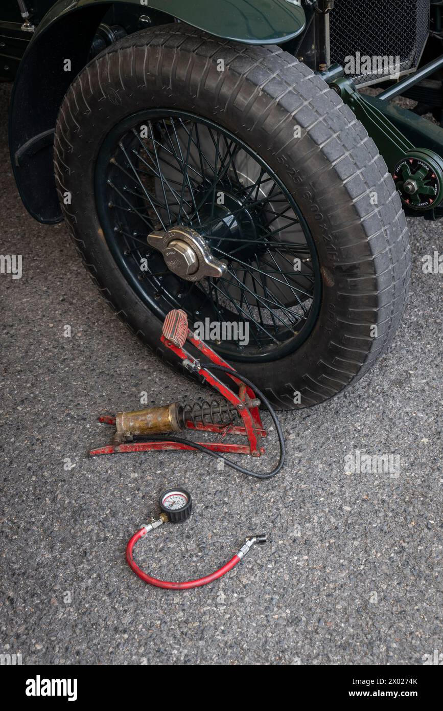 A Bentley wheel and tyre beside a foot pump and pressure gauge in the paddock at the 2023 Goodwood Revival, Sussex, UK. Stock Photo