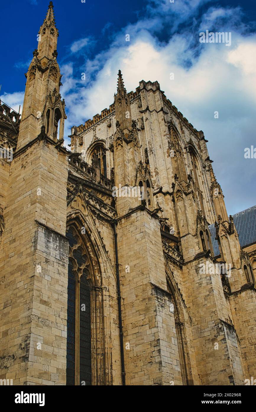 Gothic cathedral facade against a blue sky with clouds. The image ...