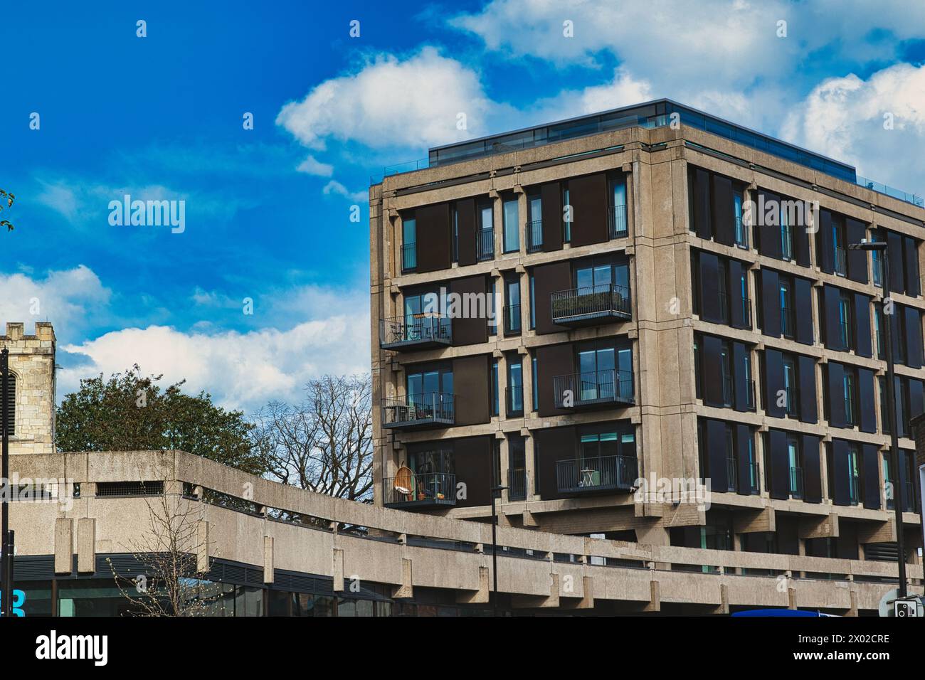 Modern urban apartment building with balconies against a blue sky with ...