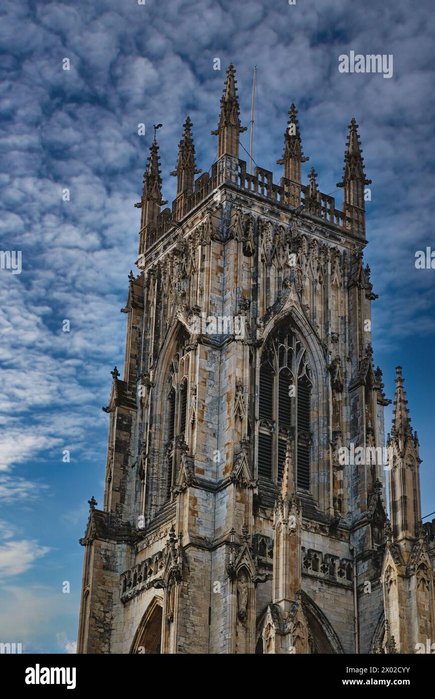 Gothic cathedral tower against a dramatic cloudy sky, showcasing ...
