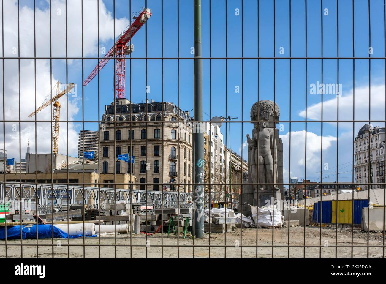 Cranes at work on a building site near the Place des armateurs and the Vergote basin on the Brussels Canal - Metallic fence to protect from intrusion Stock Photo