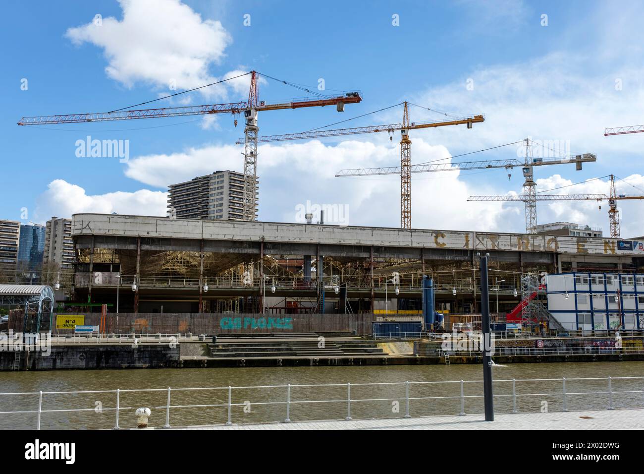 Cranes at work on a building site near the Place des armateurs and the Vergote basin on the Brussels Canal |  Grues au travail sur un chantier pres du Stock Photo