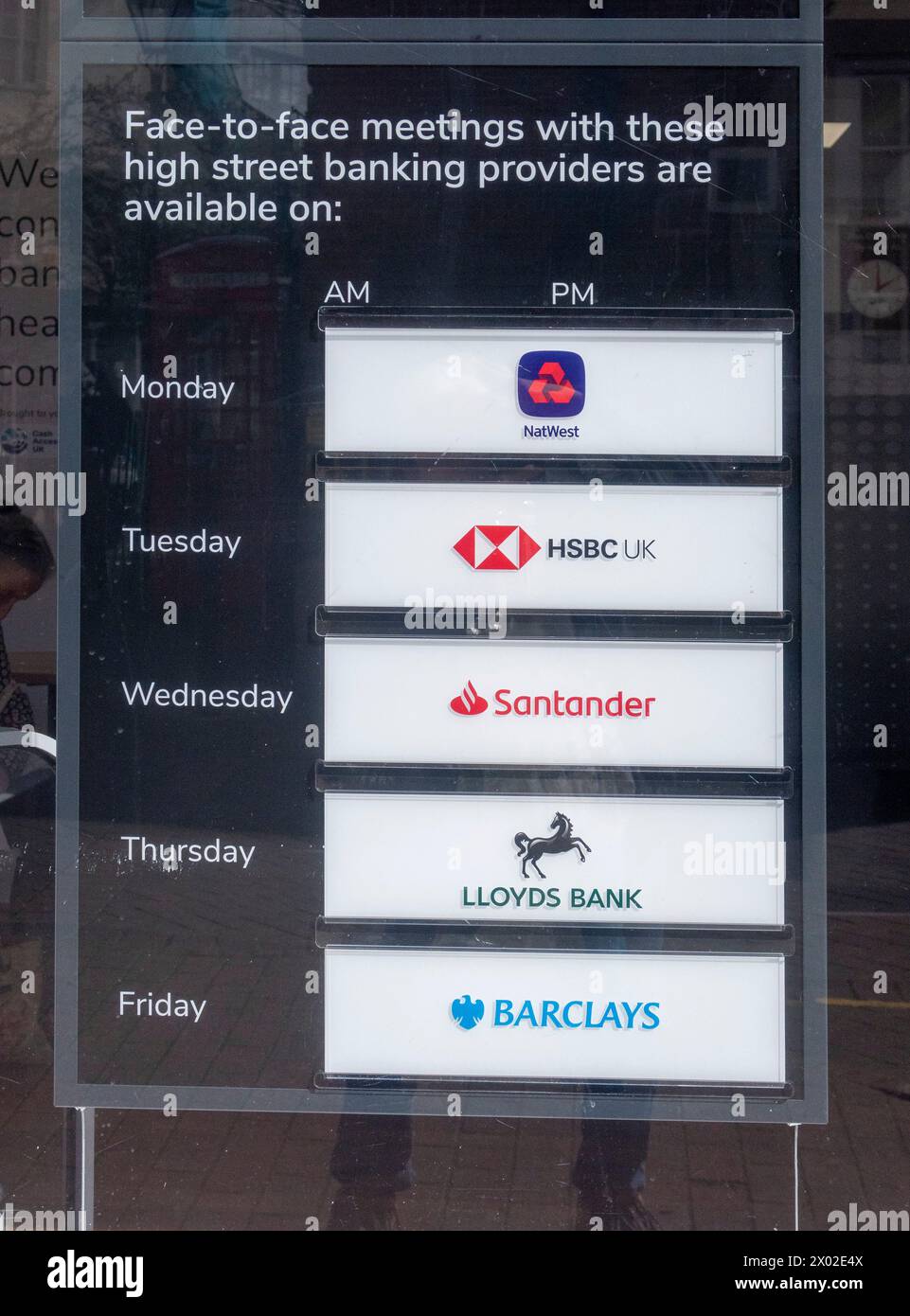 Notice in the window of a new banking hub in Sidmouth, Devon showing which banks operate there on which days. Stock Photo