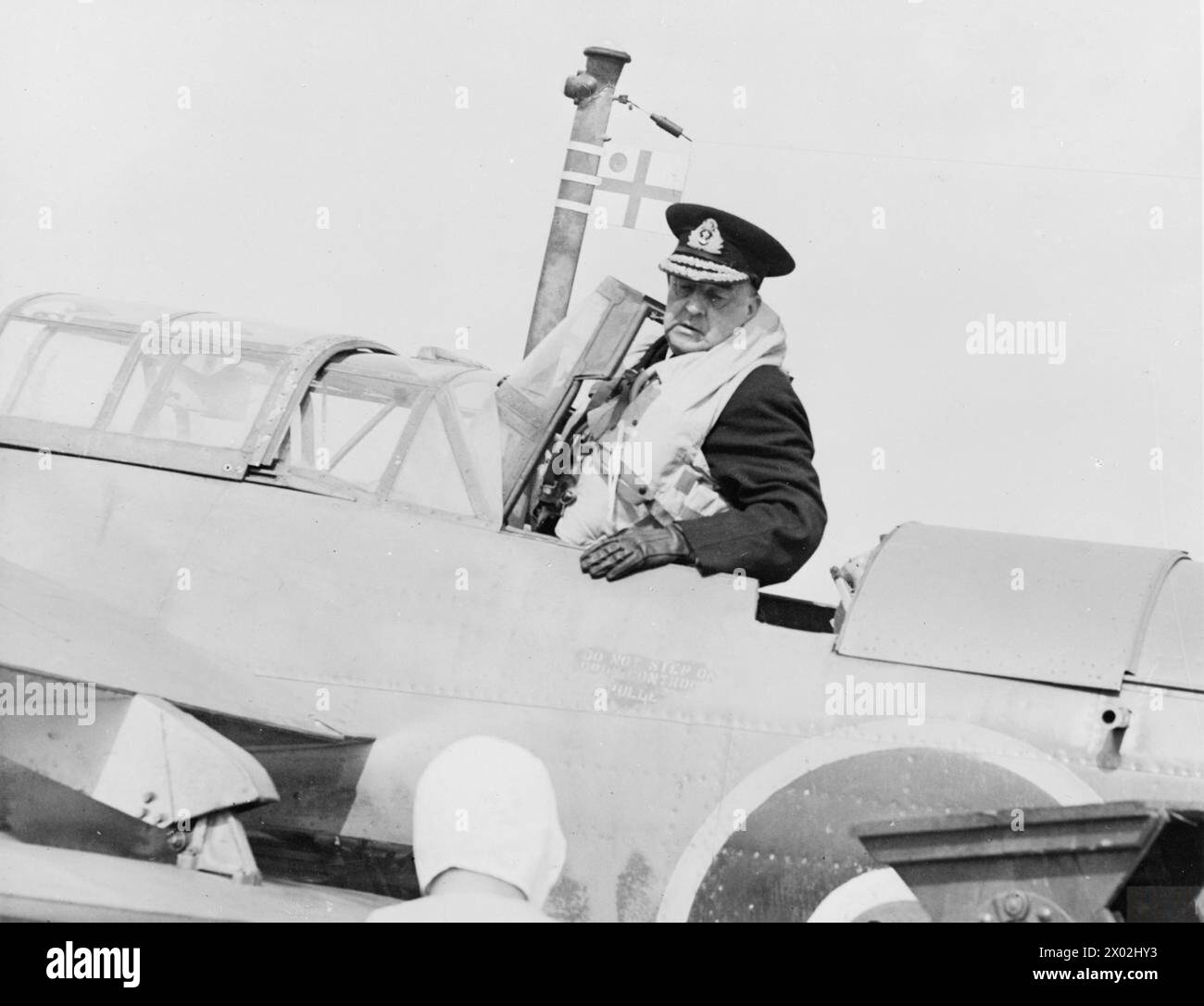 FLYING ADMIRAL. MAY 1945, HMS PEEWIT, ROYAL NAVAL AIR STATION, EAST HAVEN, NEAR ARBROATH. VICE ADMIRAL SIR A L ST G LYSTER, KCB, CVO, CBE, DSO, FLAG OFFICER IN CHARGE OF CARRIER TRAINING, AS HE PREPARED TO MAKE A FLYING VISIT TO THE BRITISH ESCORT CARRIER HMS SMITER. IT WOULD BE HIS 107TH DECK LANDING, AND HE HAS LANDED ON OVER 50 CARRIERS. - Vice Admiral Lyster entering the Fairey Barracuda at HMS PEEWIT. Note the Admiral's flag on the aircraft Stock Photo