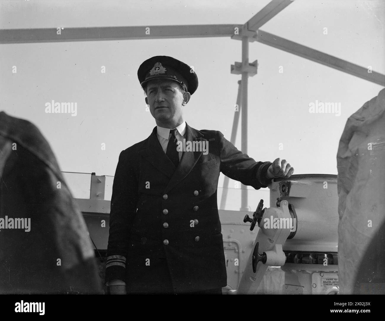 Lieutenant Commander R.H. Bristow, DSO, RN, stands on the bridge of HMS ...
