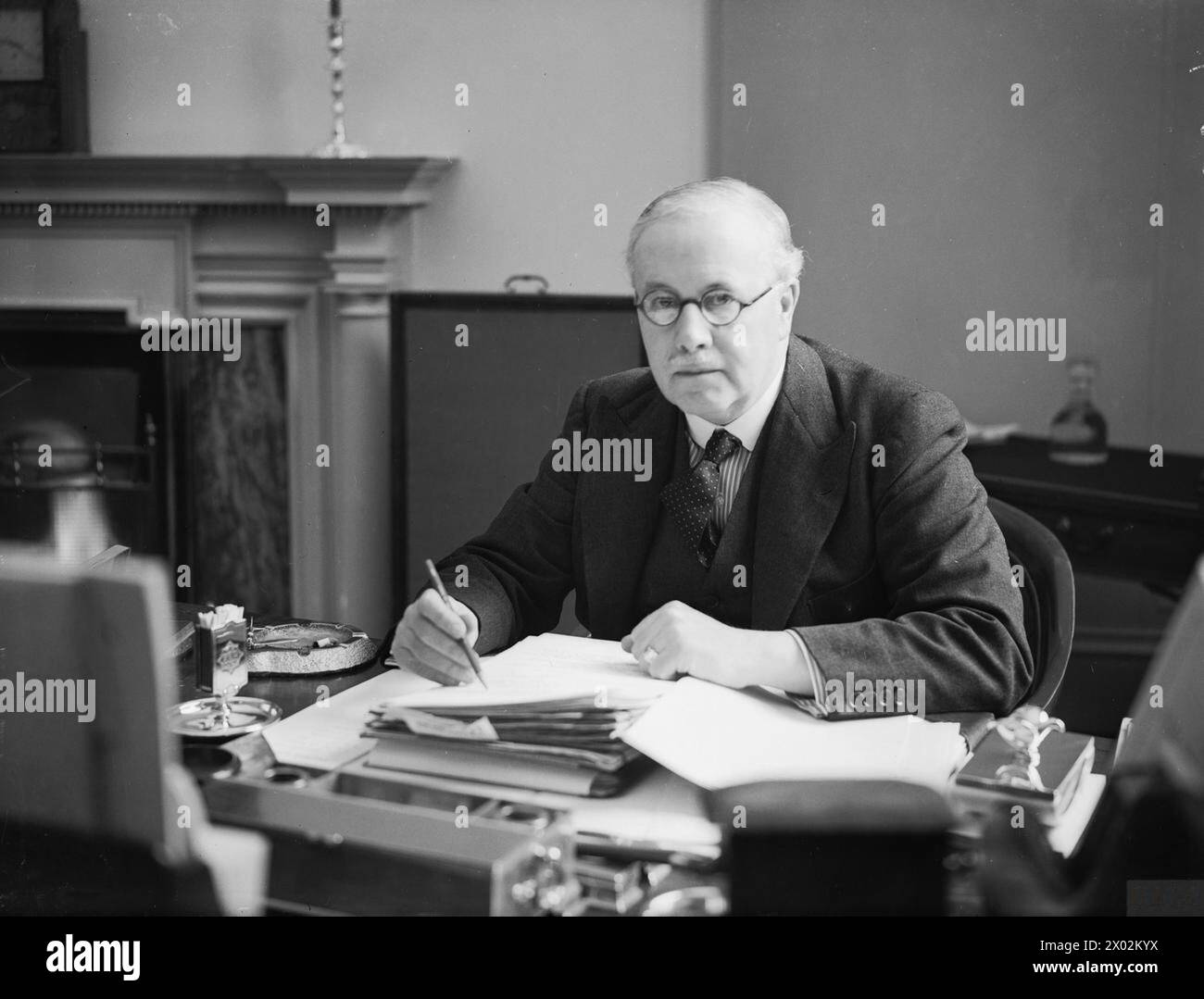 BRITISH POLITICAL PERSONALITIES 1936-1945 - The Neville Chamberlain War Cabinet 3 September 1939 - 10 May 1940: Sir Kingsley Wood, the Secretary of State for Air from September 1939 to April 1940, seated at his desk at the Air Ministry  Kingsley Wood, Howard Stock Photo