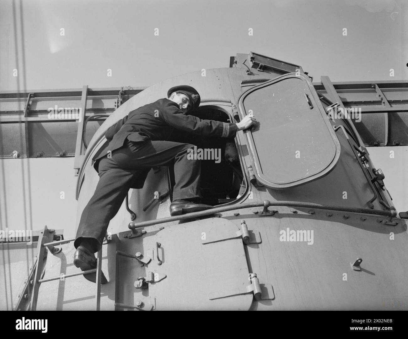 Lieutenant Commander J J Casement climbing into the gun director on ...