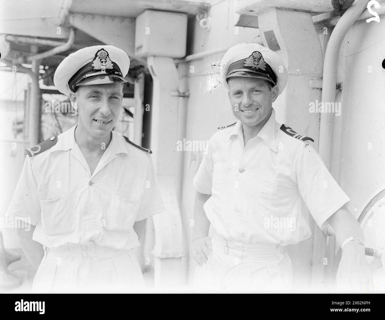 SHATTERED JAPANESE CONVOY. 4 APRIL 1945, TRINCOMALEE, ON BOARD THE DESTROYER HMS SAUMAREZ. OFFICERS AND MEN OF HMS SAUMAREZ, PART OF THE EAST INDIES FLEET WHICH SHATTERED A JAPANESE CONVOY AND ESCORTS IN THE ANDAMAN SEA IN MARCH 1945. - Gunner (T) Mr E W M Peters, DSM, RN, of Pitsea, Essex, with the First Lieutenant, Lieut Cdr J Lennox-King, RNZNVR, of Auckland, NZ Stock Photo