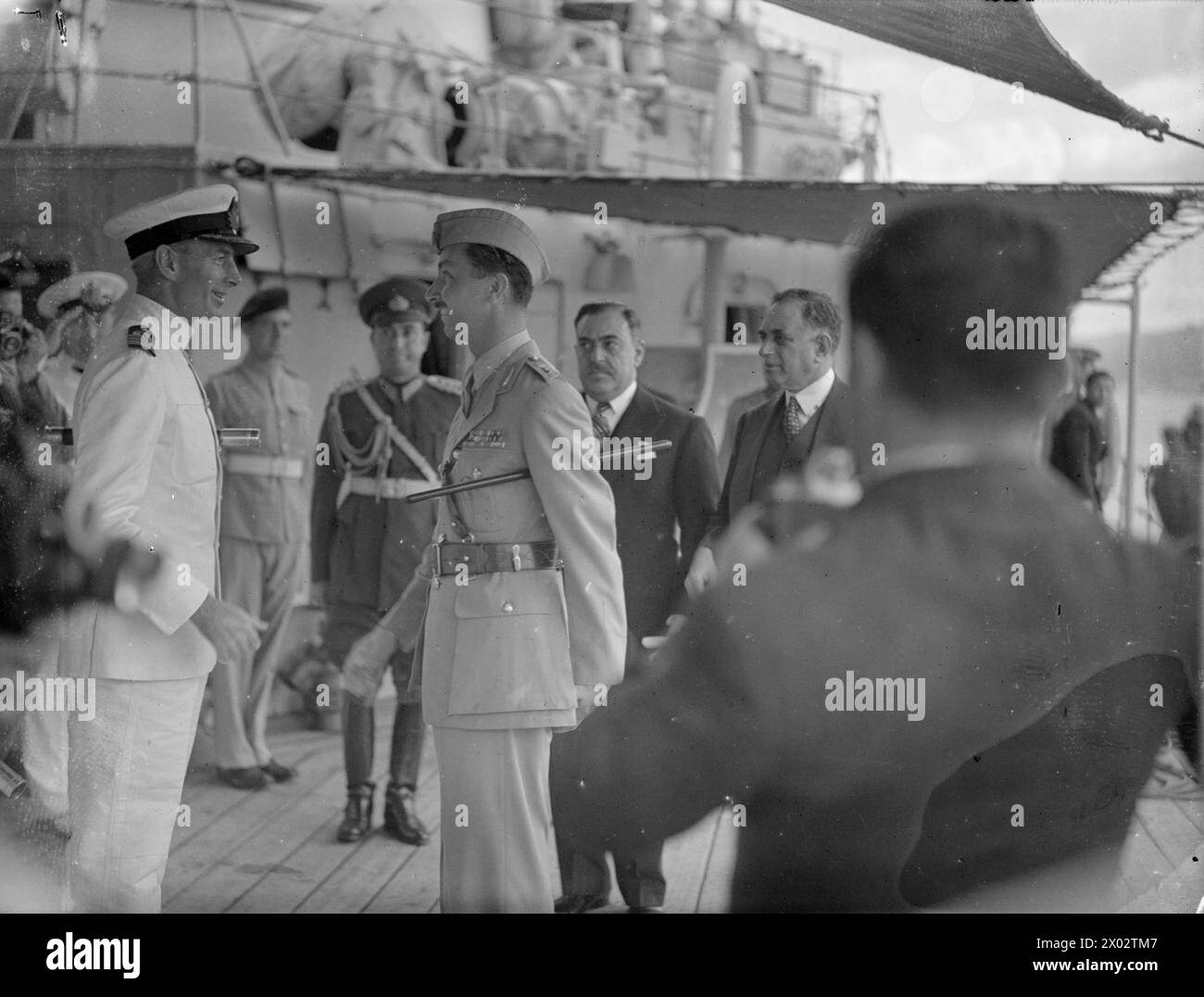 THE BRITISH CRUISER HMS AJAX VISITS TURKEY. 15 TO 18 SEPTEMBER 1945, ON BOARD HMS AJAX, AND ASHORE AT ISTANBUL. DURING THE VISIT OF HMS AJAX AND THE DESTROYERS HMS MARNE AND HMS METEOR TO ISTANBUL. ON BOARD THE CRUISER WAS HRH EMIR ABDUL ILLAH, REGENT OF IRAQ, AND HIS STAFF. ON 16 SEPTEMBER 1945 CAPTAIN J CUTHBERT, RN, OF THE AJAX LAID A WREATH ON THE TURKISH INDEPENDENCE MEMORIAL IN TAKSIM SQUARE, ISTANBUL, AND THE NEXT DAY THE CRUISER WAS OPEN TO VISITORS. - The Regent of Iraq, HRH Emir Abdul Illah, taking leave of Captain Cuthbert of the AJAX on proceeding ashore,(GOC Istanbul is in the bac Stock Photo