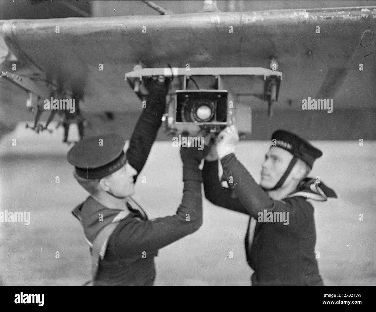 TRAINING OF NAVAL PILOTS FOR NAVAL AIRCRAFT. 1941, HMS JACKDAW, ROYAL NAVAL AIR STATION CRAIL, FIFE. - Adjusting the torpedo aiming camera to the wing of the Fairey Swordfish. The camera is used for checking accuracy during practice attacks Stock Photo