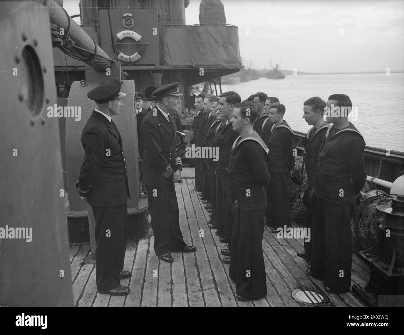 Captain H G Hopper inspects the crew of the minesweeper HMT Wardour on ...
