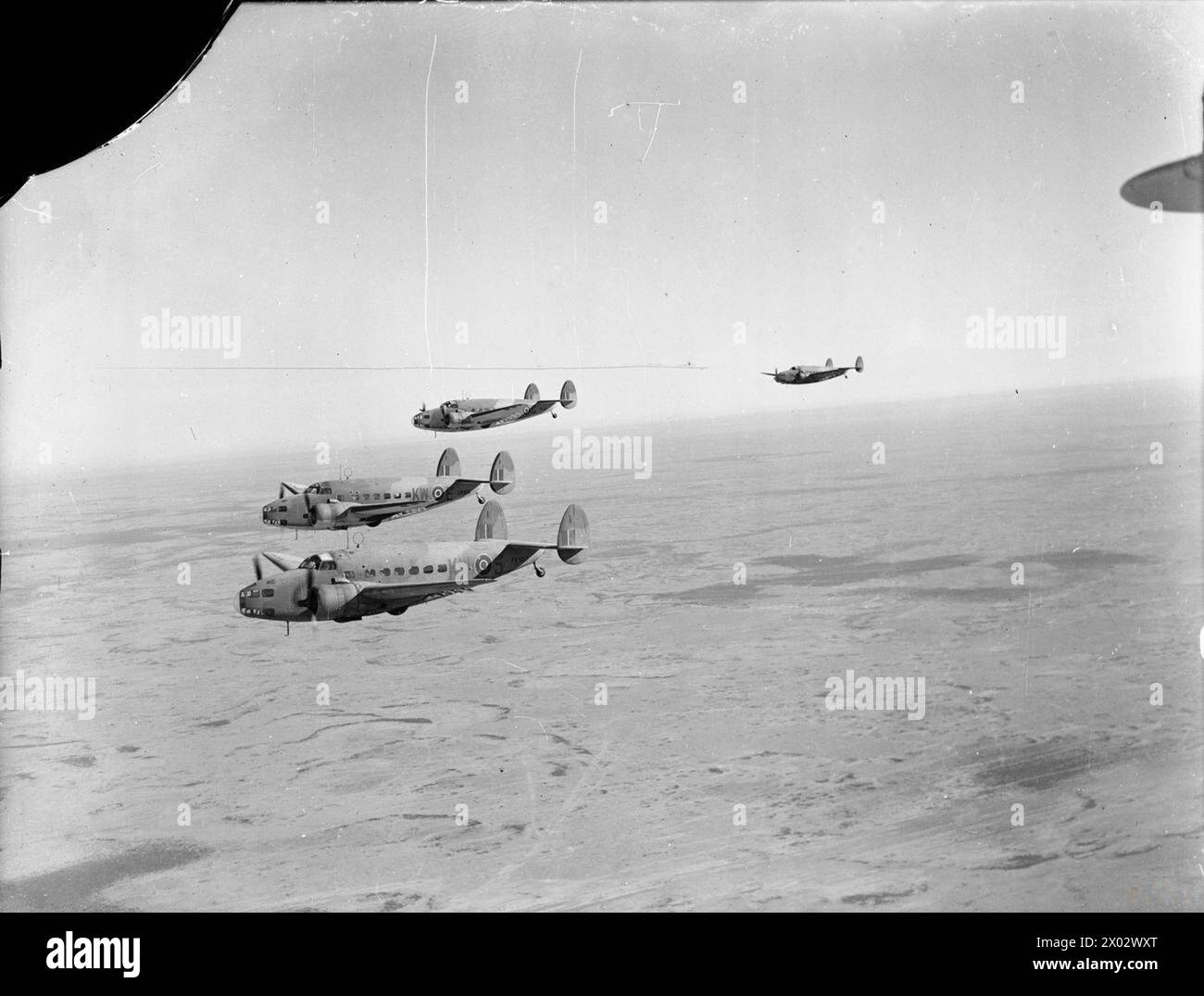 ROYAL AIR FORCE OPERATIONS IN THE MIDDLE EAST AND NORTH AFRICA, 1939-1943. - Three Lockheed Hudson Mark VI transports, (including FK507 KW-S, EW889 KW-E and EW887 KW-C), of No. 267 Squadron RAF based at LG224/Cairo West, Egypt, flying troops to Castel Benito, Tripoli, on an Operation HELPFUL flight  Royal Air Force, Maintenance Unit, 267 Stock Photo