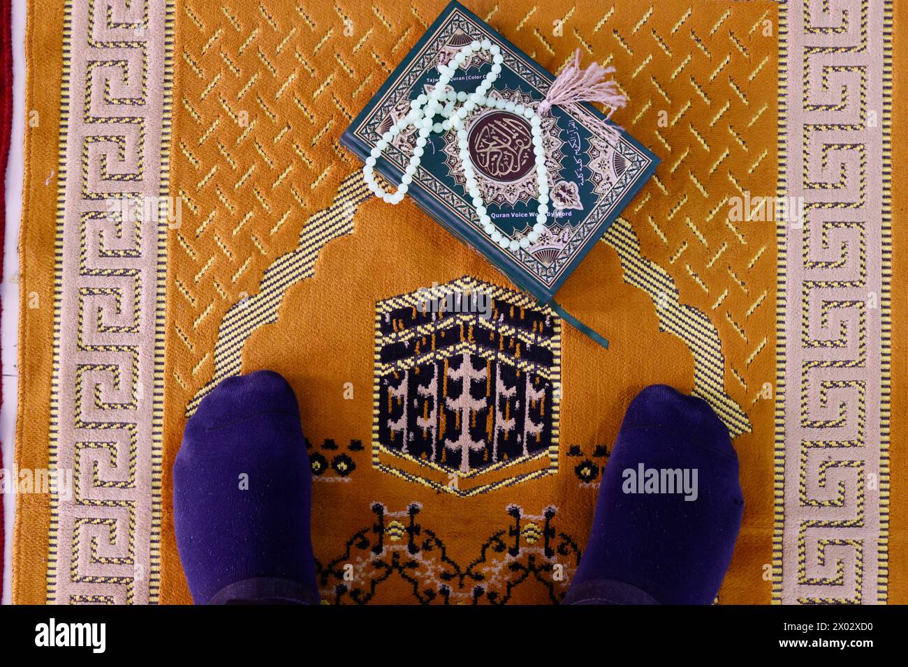 Muslim man praying on Islamic prayer mat with the Kaaba, Symbol of Islam, Chau Doc, Vietnam, Indochina, Southeast Asia, Asia Stock Photo