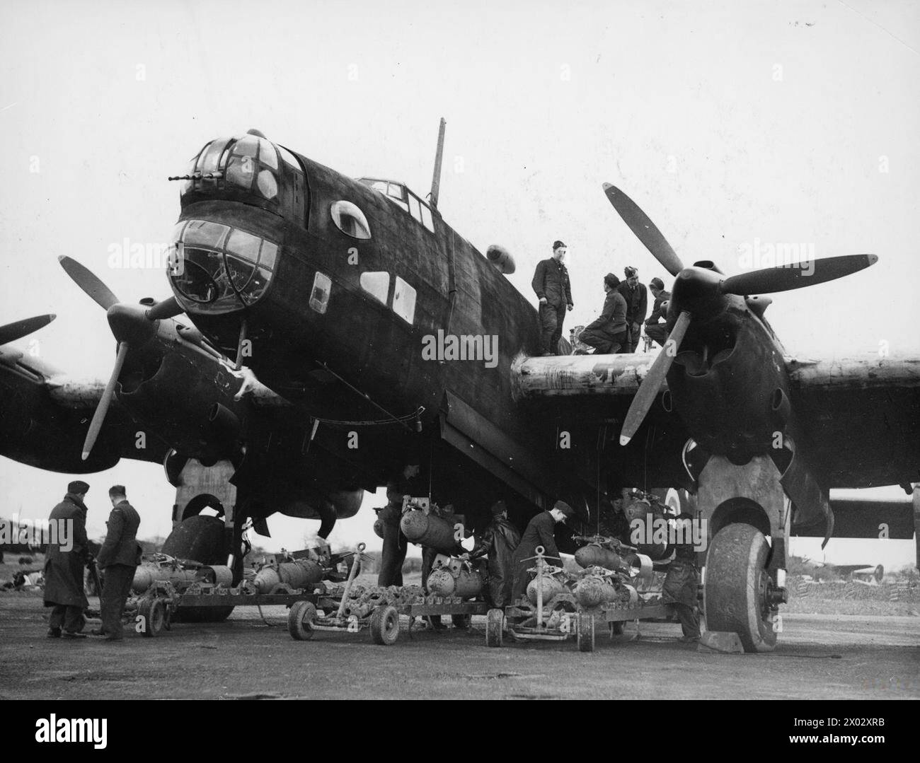 RAF BOMBER COMMAND - Ground staff 'bombing up' a Handley Page Halifax Mk II of No. 76 Squadron at Middleton St. George, October 1941 Stock Photo