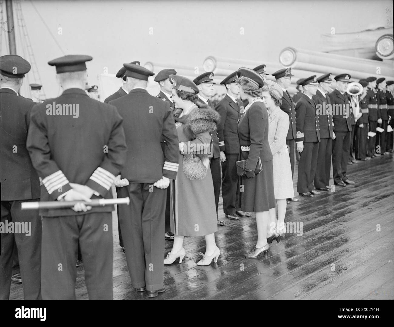 ROYAL VISIT TO HMS KING GEORGE V. 29 OCTOBER 1944, GREENOCK. THE KING AND QUEEN ACCOMPANIED BY PRINCESS ELIZABETH AND PRINCESS MARGARET PAID A FAREWELL VISIT TO THE BATTLESHIP HMS KING GEORGE V BEFORE SHE LEFT TO JOIN BRITAIN'S EAST INDIES FLEET. - The Queen and the Princesses meeting ship's officers on the quarterdeck Stock Photo