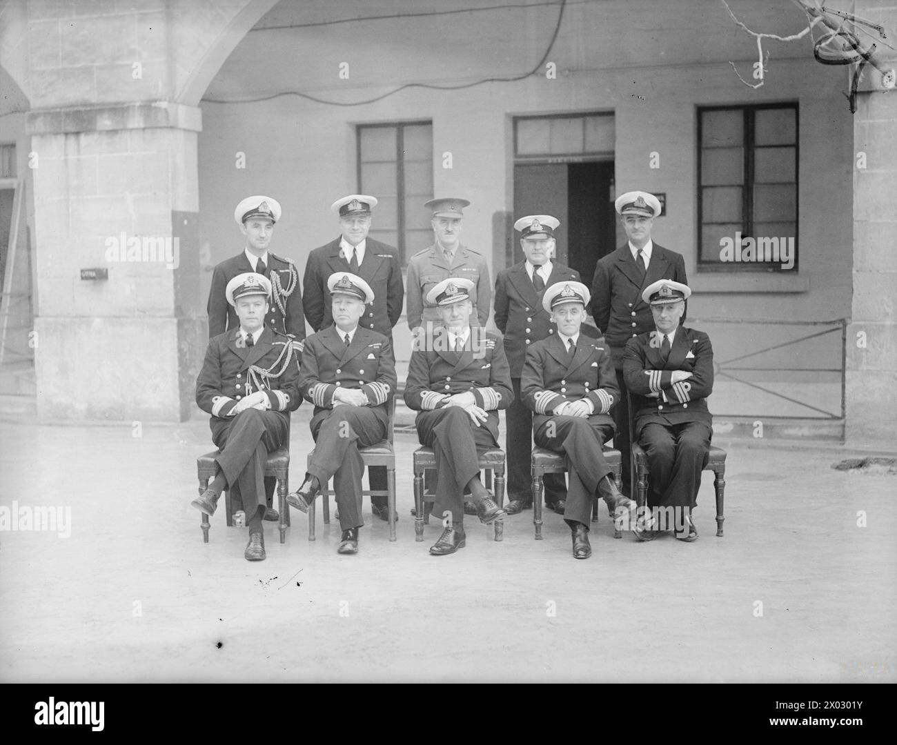 ADMIRAL SIR WILBRAHAM FORD AND HIS STAFF BEFORE HE LEFT MALTA TO BECOME C IN C ROSYTH. 1941, MALTA. - Admiral Sir Wilbraham Ford with a group of Naval Officers at Malta. Left to right: back row: Lieut Cdr W H B Wallace; Lieut Cdr H R B Howell; Major O E Haworth-Booth, RM; Lieut Cdr G Finley-Day; Commander M J Evans. Front Row: Pay Cdr R H Johnson; Captain G W Wadham, Chief of Staff; Admiral Sir Wilbraham Ford, KCB, KBE; Eng Captain H E Lewis; Commander P H Calderson Stock Photo