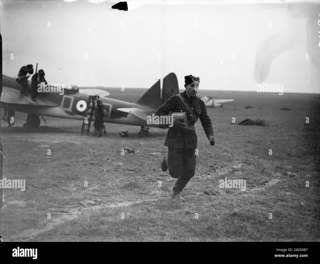ROYAL AIR FORCE: FRANCE, 1939-1940 - A corporal runs to a waiting car with a magazine of undeveloped film from an F.24 aerial camera, just handed over by the aircrew of a Bristol Blenheim Mark IV of No. 139 Squadron RAF at Bétheniville, after a photo-reconnaissance sortie  Royal Air Force, 139 Squadron, Royal Air Force, Advanced Air Striking Force Stock Photo