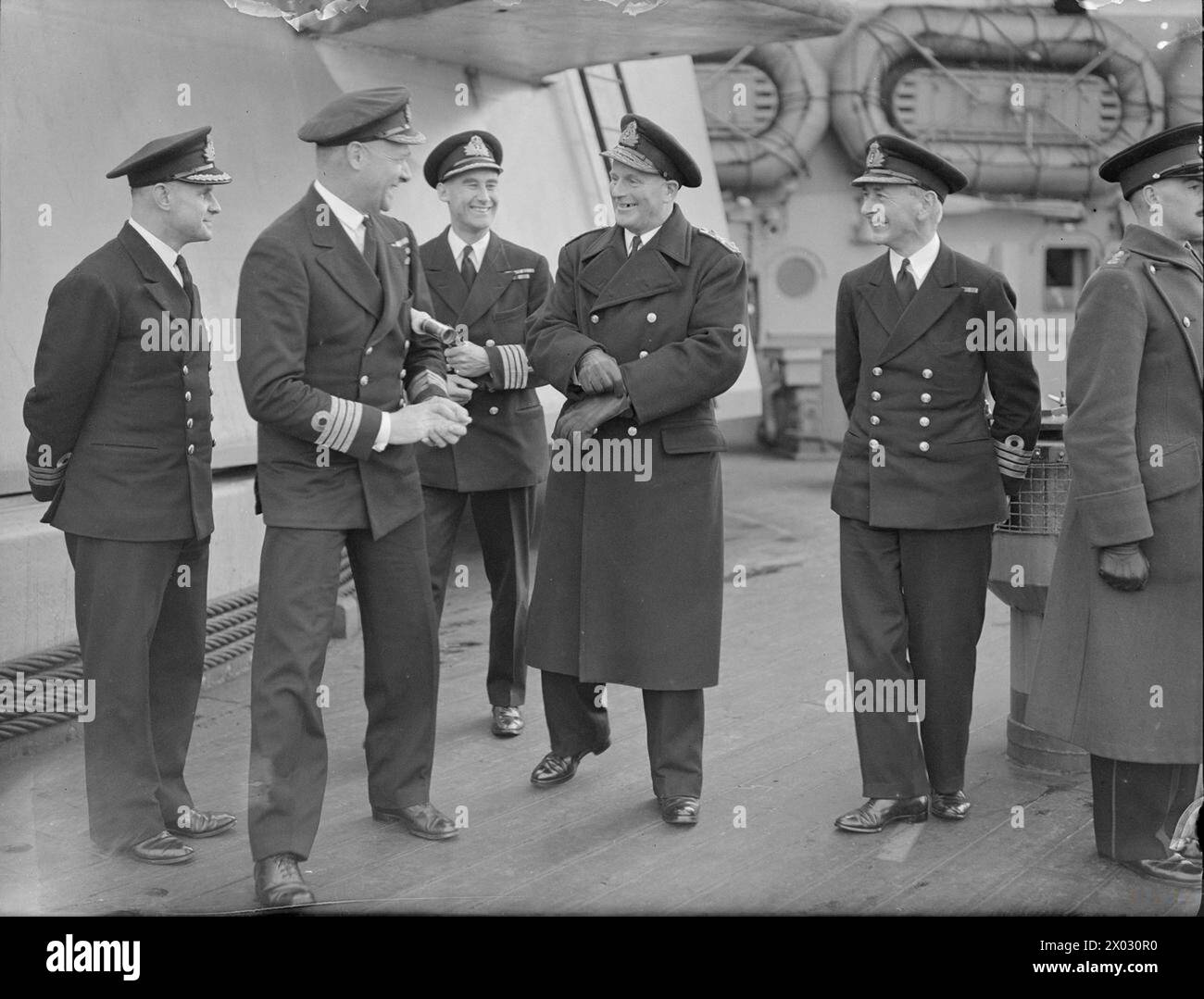 REAR ADMIRAL I G GLENNIE RAD HOME FLEET VISITS C-IN-C HOME FLEET. 13 JANUARY 1943, SCAPA FLOW. - Rear Admiral I G Glennie, who relieved Rear Admiral R L Burnett in Command of Home Fleet destroyers, shown with officers of the Fleet Flagship, HMS KING GEORGE V, after calling in on the C-in-C Home Fleet. Left to right: Commander E F H C Rutherford, RN; Captain P J Mack, DSO, RN; Captain A E M B Cunningham-Grahm, RN; Rear Admiral I G Glennie; Captain F B Lloyd, OBE, RN Stock Photo