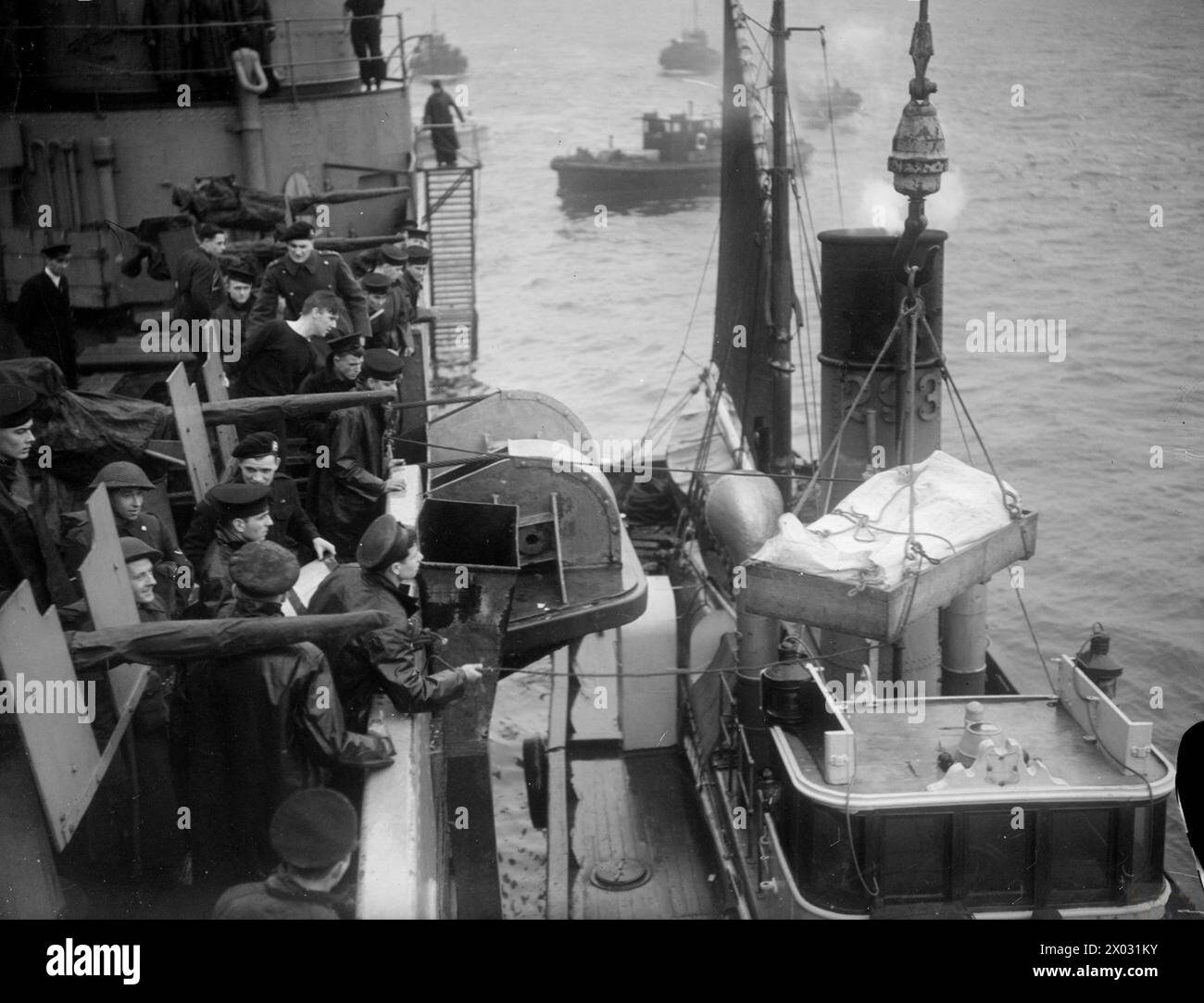 SINKING OF THE SCHARNHORST. 1 JANUARY 1944, SCAPA FLOW. ON 26 DECEMBER 1943, ONE OF GERMANY'S FEW GREAT WARSHIPS, THE 26,000 TO SCHARNHORST, WAS SUNK BY UNITS OF THE HOME FLEET. THE SCHARNHORST WAS ATTEMPTING TO INTERCEPT A RUSSIAN-BOUND CONVOY WHEN SHE WAS DRIVEN OFF, CHASED, AND FINALLY DESTROYED OFF THE NORTH CAPE. SLOWED DOWN BY TORPEDOES FROM OUR DESTROYERS, AND CRIPPLED BY GUNFIRE FROM HMS DUKE OF YORK, SHE WAS SENT TO THE BOTTOM BY TORPEDOES FIRED FROM HMS JAMAICA. - A wounded SCHARNHORST prisoner being slung from the DUKE OF YORK to the hospital drifter Stock Photo