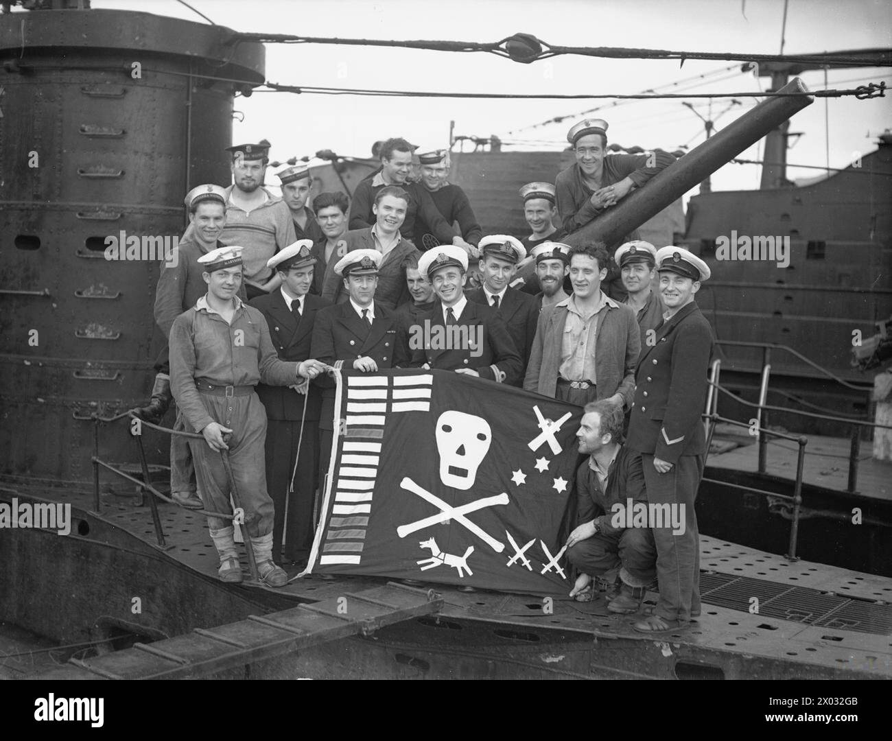 THE POLISH NAVY IN THE MEDITERRANEAN, 1940-1945 - During the patrol ORP Dzik was accompanied by her sister ship ORP Sokół (Falcon); they both were known as the 'Terrible Twins'. Officers and ratings of the Polish submarine ORP Dzik (Wild Boar) with their Jolly Roger of success after the last patrol of their first commission at Gibraltar, March 1943. Lieutenant Bolesław Romanowski (known as 'Bolko' to his fellow submariners), the CO of the submarine, can be seen in the front row, third from the left  Polish Navy, ORP Dzik, Polish Navy, Romanowski, Bolesław Stock Photo