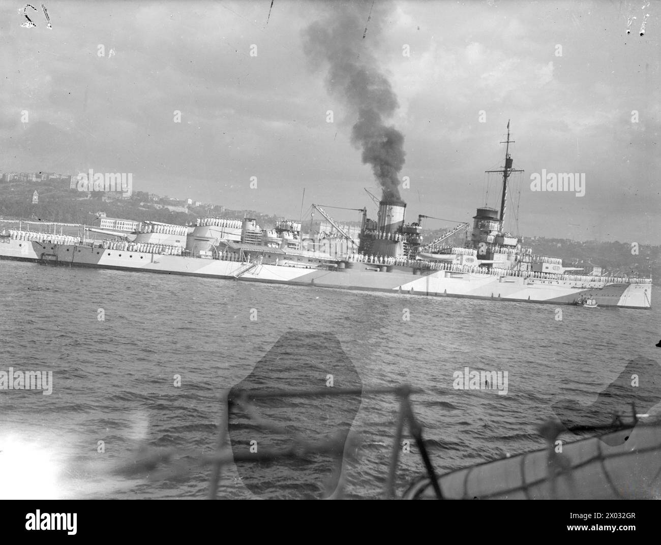 THE BRITISH CRUISER HMS AJAX VISITS TURKEY. 15 TO 18 SEPTEMBER 1945, ON BOARD HMS AJAX, AND ASHORE AT ISTANBUL. DURING THE VISIT OF HMS AJAX AND THE DESTROYERS HMS MARNE AND HMS METEOR TO ISTANBUL. ON BOARD THE CRUISER WAS HRH EMIR ABDUL ILLAH, REGENT OF IRAQ, AND HIS STAFF. ON 16 SEPTEMBER 1945 CAPTAIN J CUTHBERT, RN, OF THE AJAX LAID A WREATH ON THE TURKISH INDEPENDENCE MEMORIAL IN TAKSIM SQUARE, ISTANBUL, AND THE NEXT DAY THE CRUISER WAS OPEN TO VISITORS. - Turkish flagship YAVUZ with side manned as Ajax passes  Yavuz Stock Photo