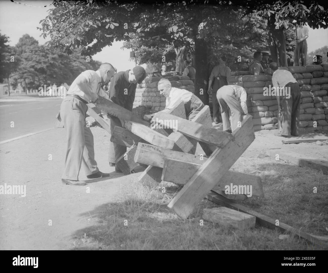 THE LOCAL DEFENCE VOLUNTEERS, 1940 - Members of the Local Defence Volunteers (LDV) construct wooden road barricades and a sandbagged defence post at Woodford Wells, Essex, 1 July 1940 Stock Photo