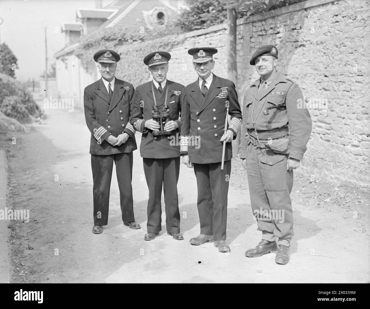 ADMIRAL LORD KEYES IN FRANCE. 6 JULY 1944, ARROMANCHES, NORMANDY. - Left to right: Capt H S M Harrison Wallace, DSO, RN, Captain H Hickling, DSO, RN, Capt H Hickling, DSO, RN, NOIC Arromanches, Admiral Lord Keyes, and Major J P Kelly, DSM, RM Stock Photo