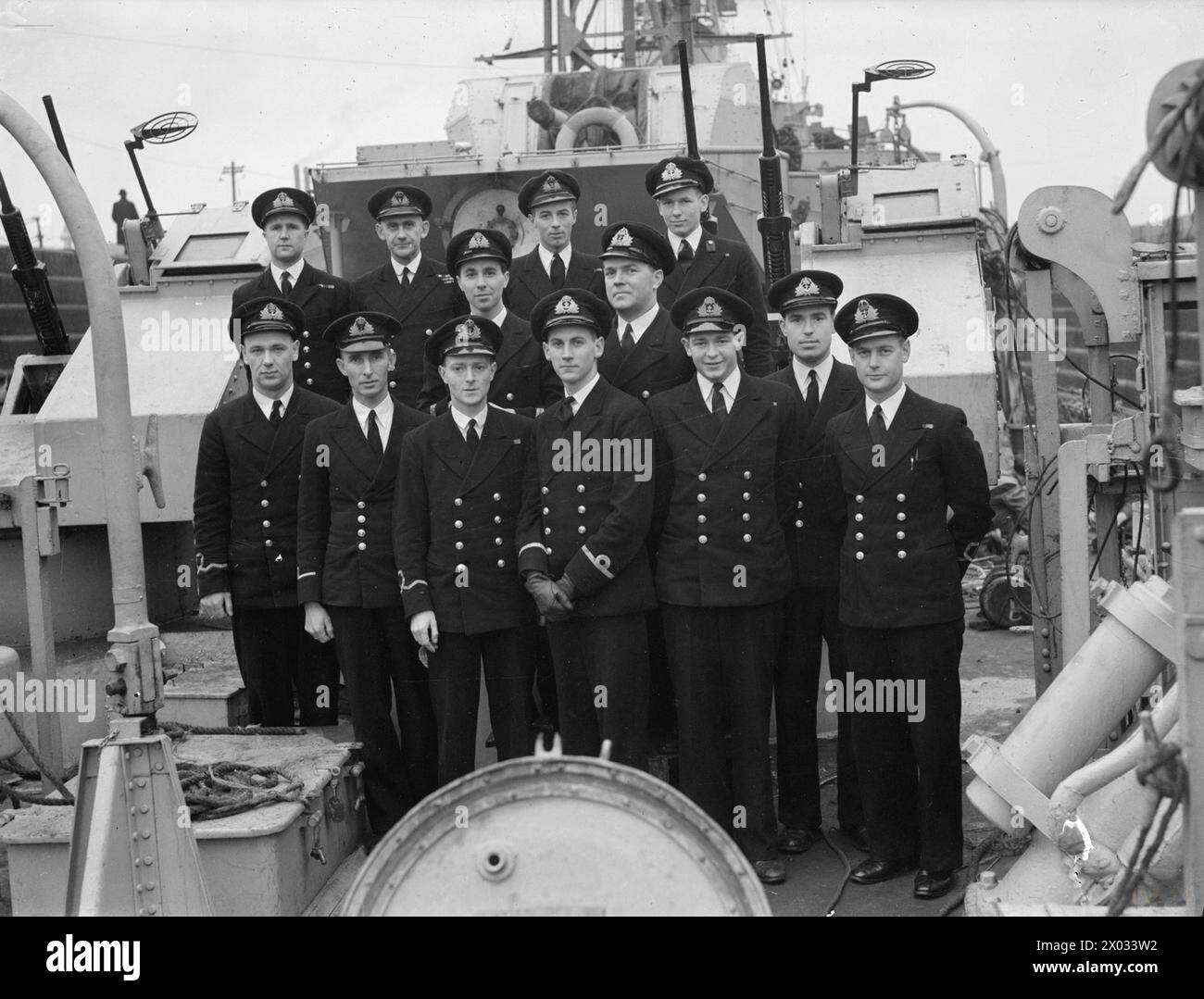 ATLANTIC RECORD BREAKERS WELCOMED HOME. 6 AND 7 MARCH 1944, LIVERPOOL, IN HMS WILD GOOSE. THE 2ND ESCORT GROUP WAS WELCOMED HOME AFTER ITS RECORD BREAKING U-BOAT HUNT IN THE NORTH ATLANTIC IN WHICH IT 'KILLED' 6 ENEMY SUBMARINES. HM SLOOP HMS WILD GOOSE WAS PART OF THE ESCORT GROUP. - Officers of the WILD GOOSE. Left to right: Back row: Lieut J Evans, DSC, RNVR, of Birmingham; Lieut Cdr D E G Wemyss, DSC and bar, RN, of Saltash and Fife; Lieut W P Chipman, RCNVR, of Ottawa; and Midshipman J W F H Dickis, RNR, of Nottingham. Centre: Surg Lieut G T Stewart, RNVR, of Elderslie; and Warrant Engine Stock Photo
