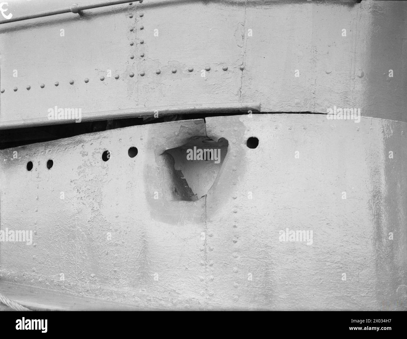 HM SUBMARINE THRASHER DAMAGED BY BOMB DROPPED FROM ENEMY AIRCRAFT. 6 MARCH 1942 ALEXANDRIA HARBOUR. The hole in the conning tower of HMS THRASHER caused by a bomb which failed to