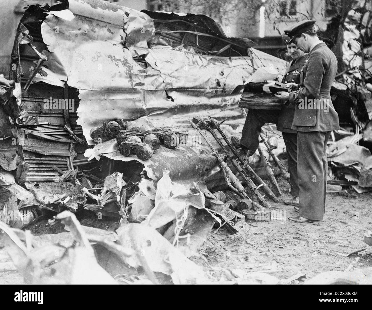 LUFTWAFFE RAIDS OVER BRITAIN - Two senior RAF officers examining the wreckage of a Heinkel He 111 which crashed at Clacton, 1 May 1940. The bomber's defensive 7.92mm MG 17 machine guns and ammunition drums have been collected together Stock Photo