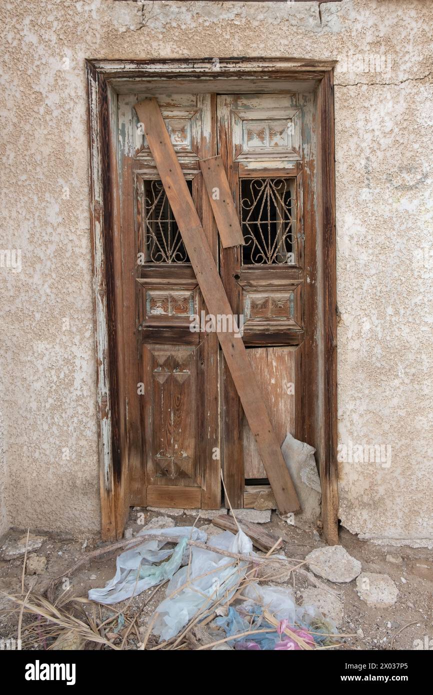 A boarded up wooden doorway to a derelict Arabian house. Stock Photo