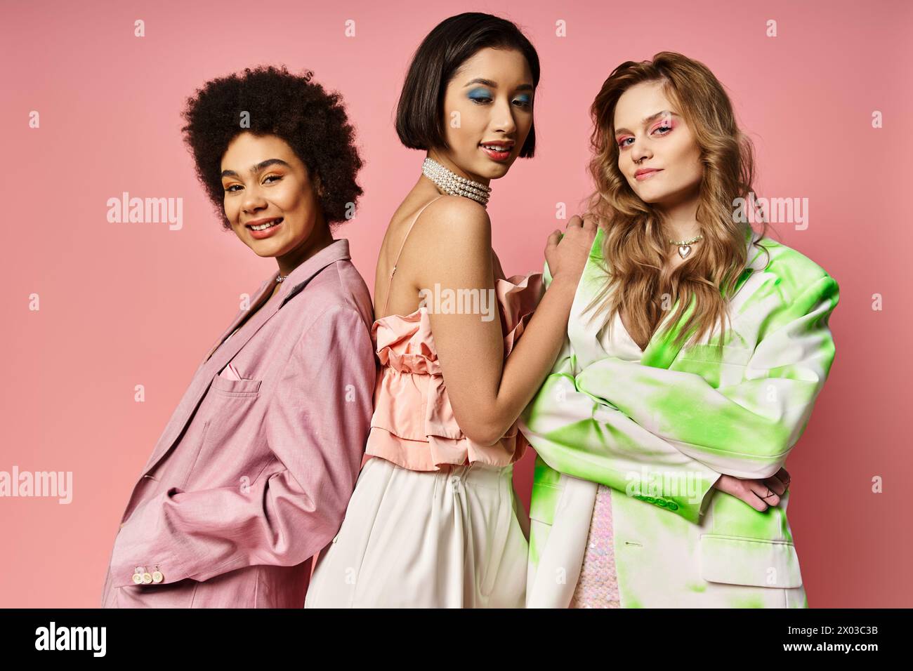 Three women of different ethnicities standing together on a pink ...