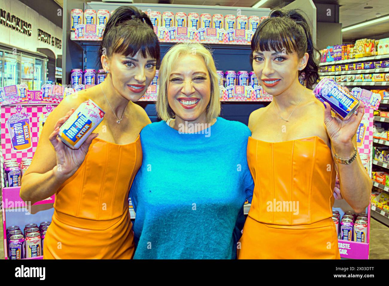 Glasgow, Scotland, UK. 9h April, 2024: Noughties pop icons the “cheeky girls” Gabrielle and Monica launch new prime drinks competitor from the makers of irn bru , exotic flavours, raspberry ripple and wild berry slush, to compete with the worldwide phenomenon drink. Customers were awed handing out samples by the ladies and local press were there as was local you tube celebrity Beverley filming on her phone. Credit Gerard Ferry /Alamy Live News Stock Photo